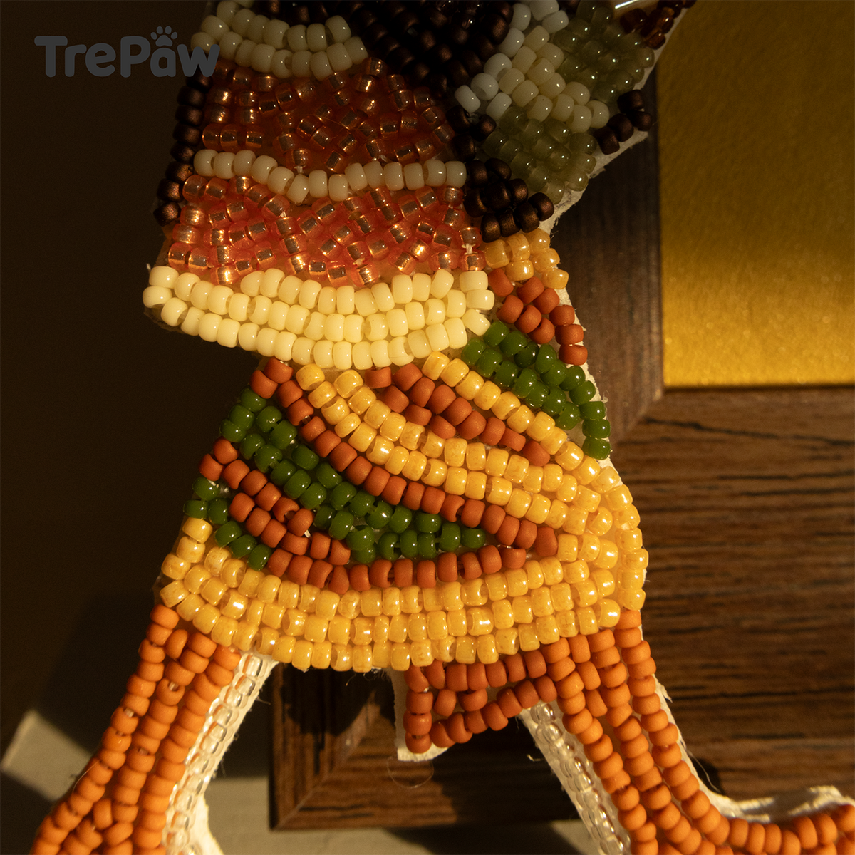 Close-up of Leopard Lady bead embroidery showing the tiny beads, burgundy top, and leopard-inspired skirt pattern.
