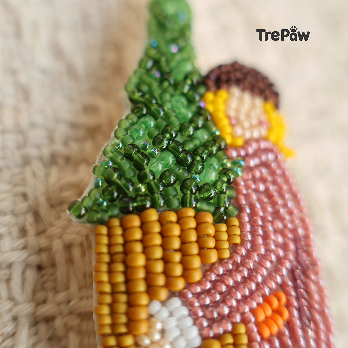 Close-up of Christmas Welcome bead embroidery showing the tiny beads, stitching, and details of the girl and potted Christmas tree.