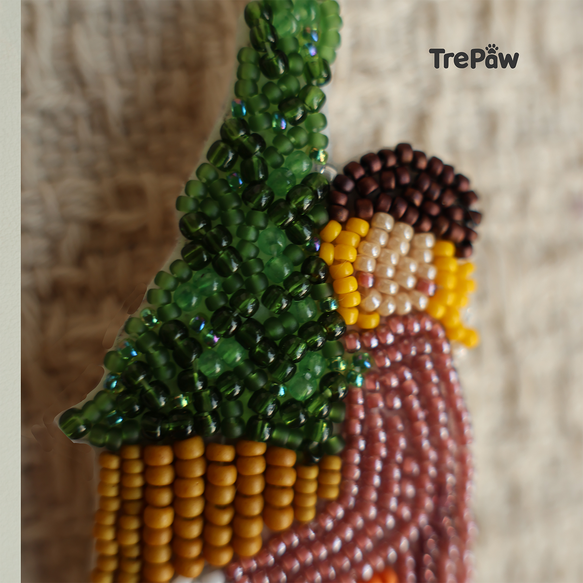 Close-up of Christmas Welcome bead embroidery showing the tiny beads, stitching, and details of the girl and potted Christmas tree.