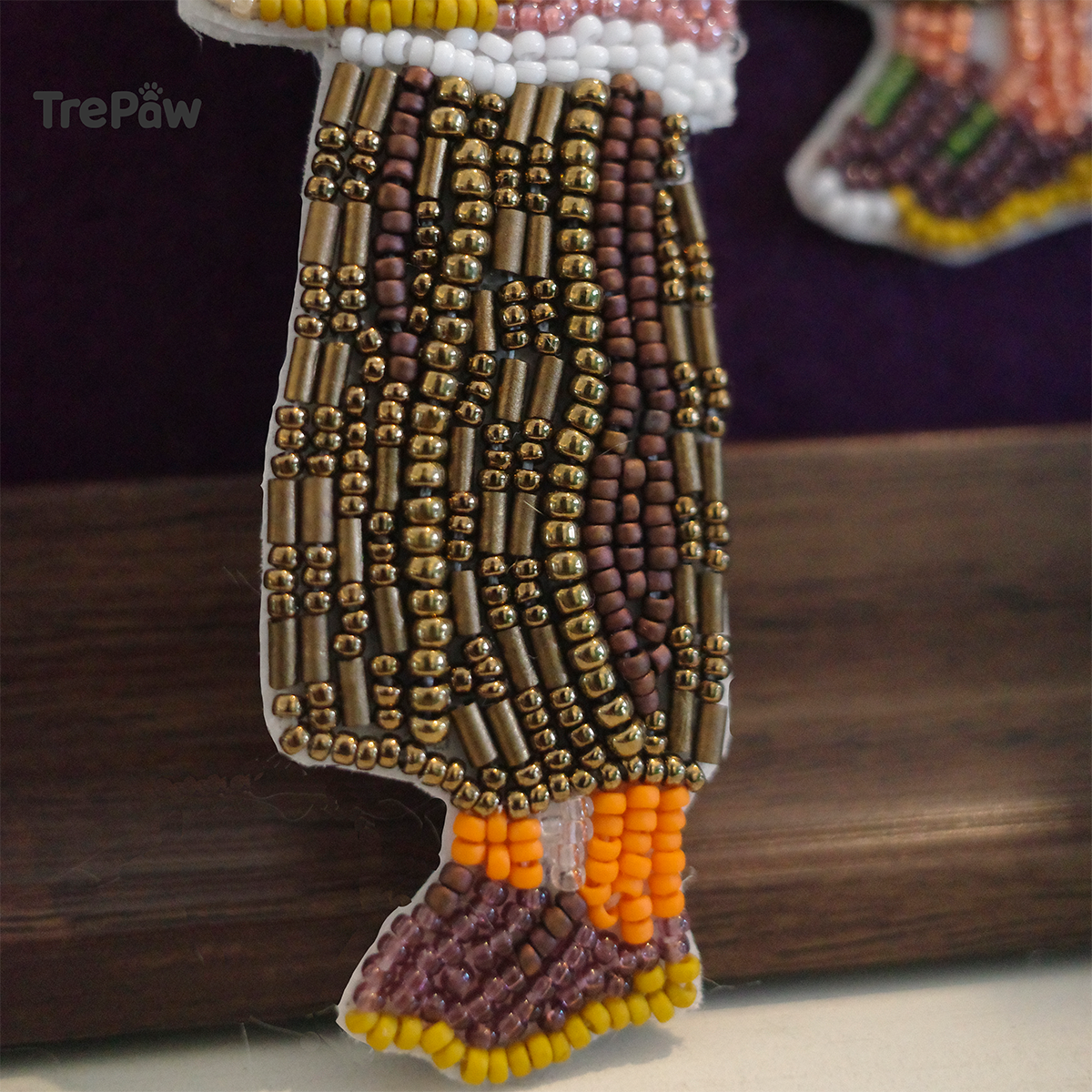 Close-up of Christmas Welcome bead embroidery showing the tiny beads, stitching, and details of the girl and potted Christmas tree.