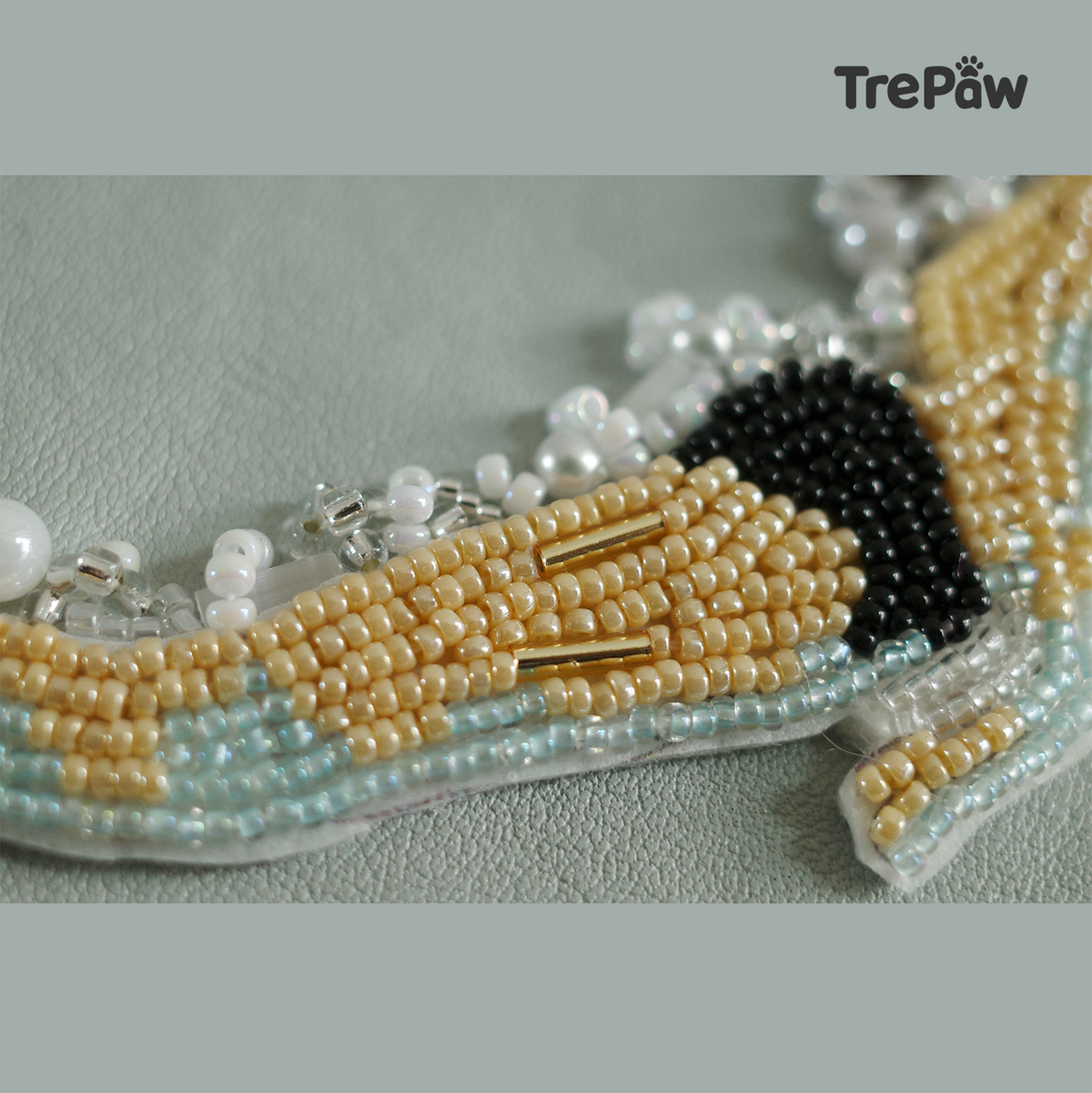 Close-up of Emerge bead embroidery showing the figure and pearl-like decorative details