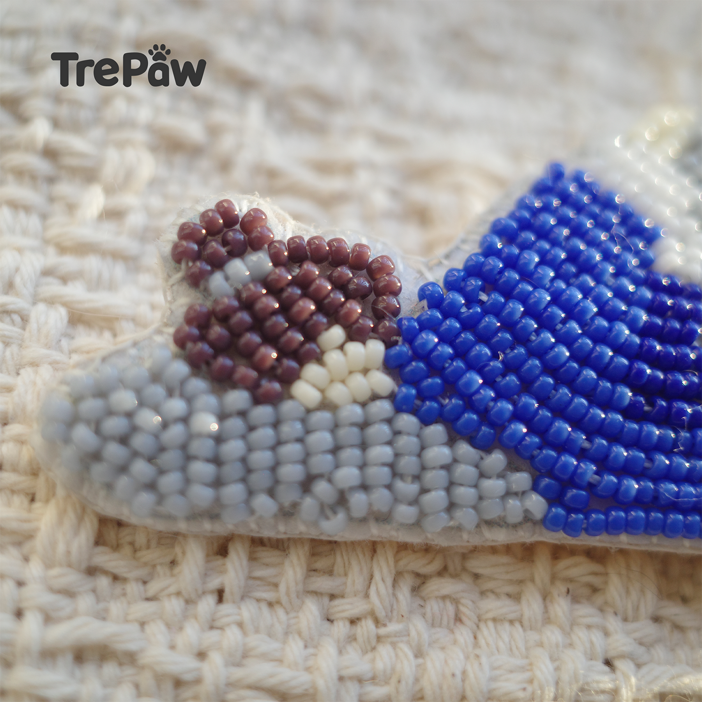Close-up of Monday Morning bead embroidery with blue pajamas and gray pillow