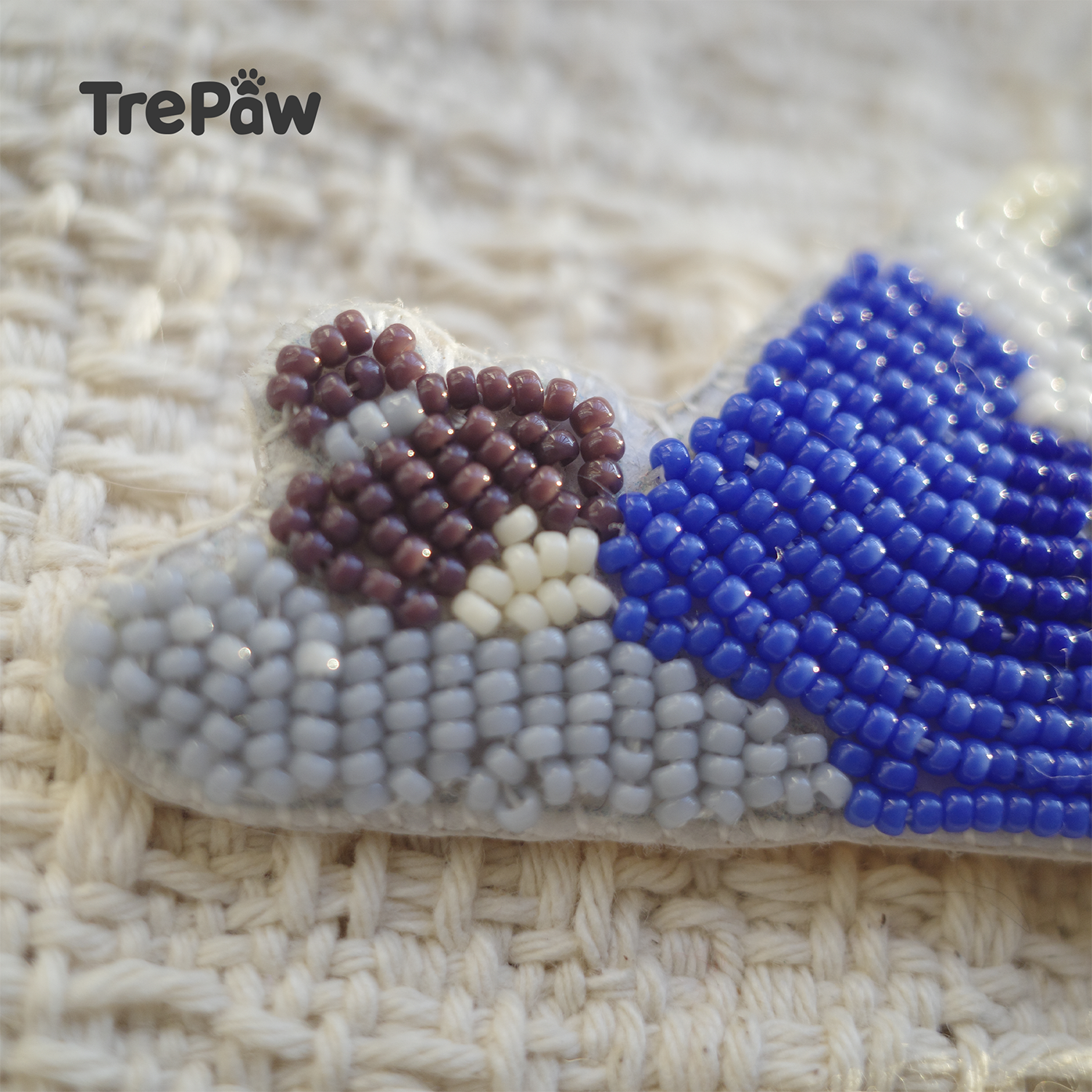 Close-up of Monday Morning bead embroidery with blue pajamas and gray pillow