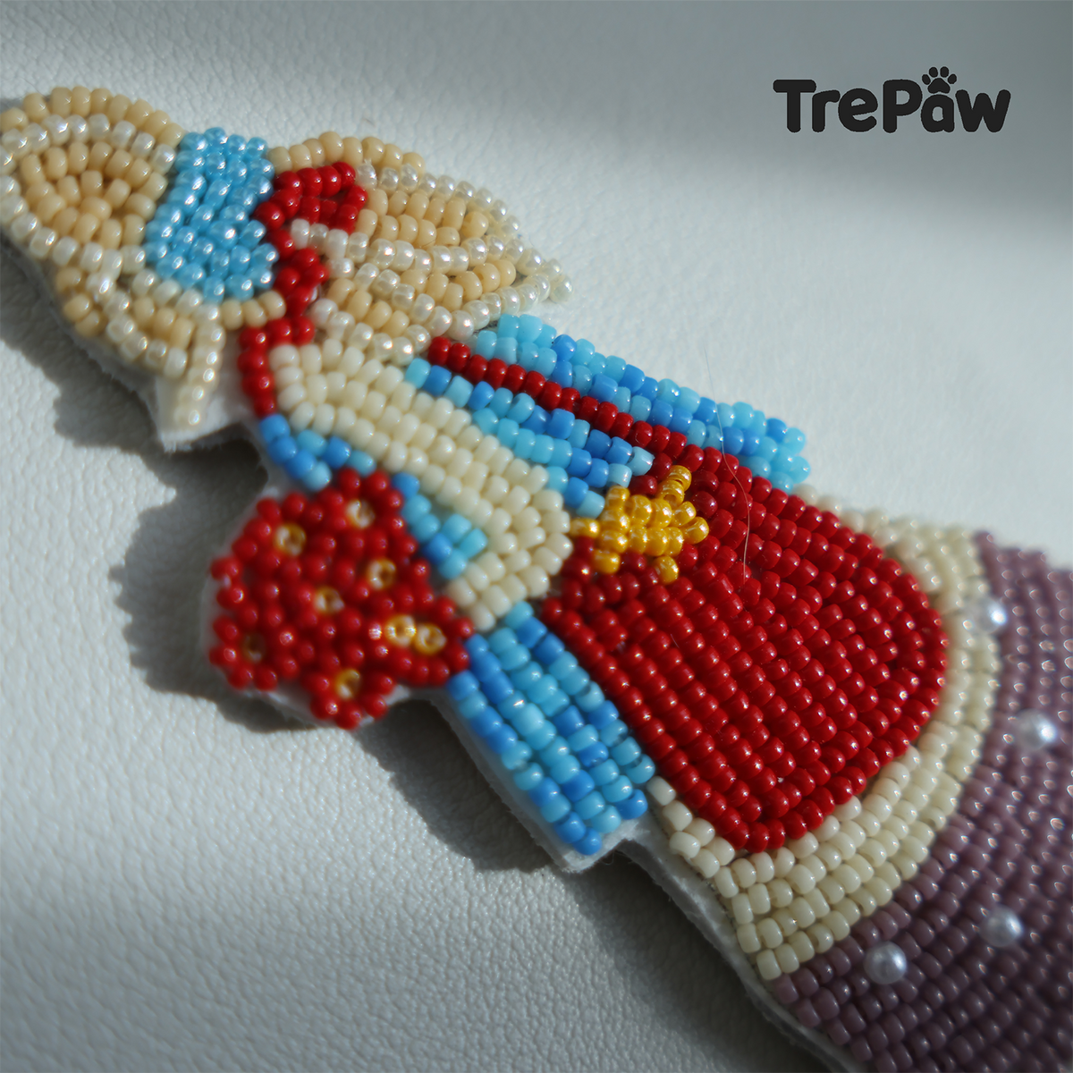 Close-up of Poppy Cream bead embroidery showing the red flower bouquet, blonde ribbon and lavender dress